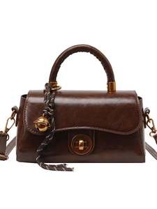 Braune Vintage-Handtasche aus Leder mit goldenem Ringverschluss und gewebtem Anhänger