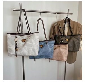 Détail de sacs cabas minimalistes avec triangle en métal et gland en plusieurs couleurs