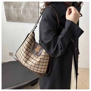 Détail du sac cabas rétro à carreaux jaune-brun avec un écusson ours brodé mignon
