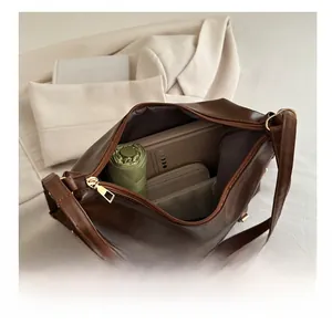 Spacious interior of brown vintage leather tote bag showing items for daily commuting