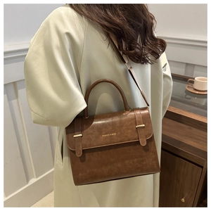 Détail du sac bandoulière vintage marron avec ferrures dorées et bandoulière réglable