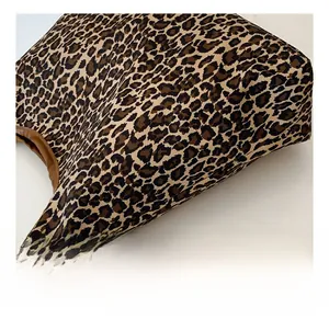 Close-up of leopard print canvas fabric and textured brown edge on a tote bag