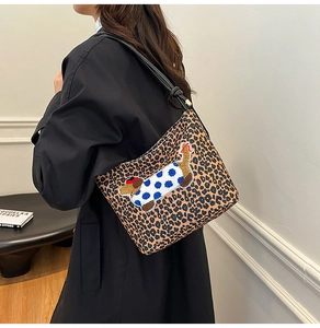 Sac seau à motif léopard avec broderie de chien porté comme un sac à bandoulière chic