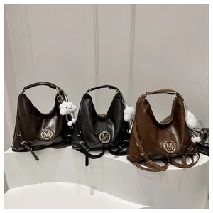 Detailed shot of retro tote bags in dark brown, black and tan with gold M logo charms