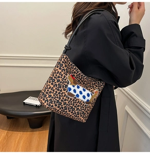 Close-up of leopard print shoulder bag featuring a cute dachshund embroidery on a model