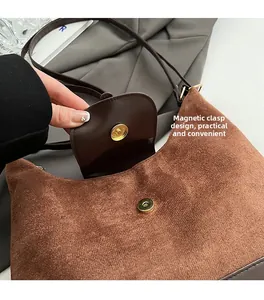 Detail of the magnetic buckle closure on a brown suede and leather vintage backpack