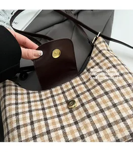 Detailed view of vintage plaid underarm bag with secure magnetic buckle closure