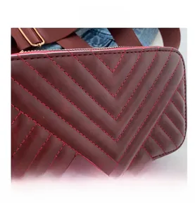 Macro shot of wine red quilted faux leather with precise V-shaped stitching detail