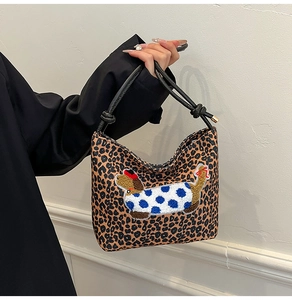 Detail of leopard print bucket bag with cute dachshund embroidery and thin black handles
