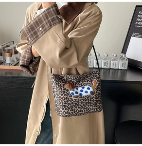 Close-up of leopard print shoulder bag with embroidered dachshund dog detail on street style