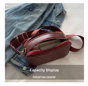 Interior view showing capacity of the burgundy quilted crossbody camera bag with zipper