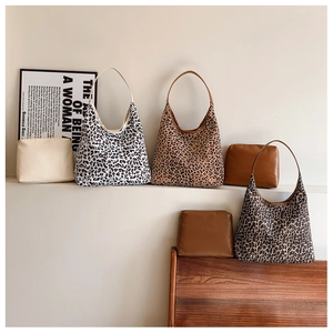 Detailed display of large leopard print tote bags with matching solid color inner pouches
