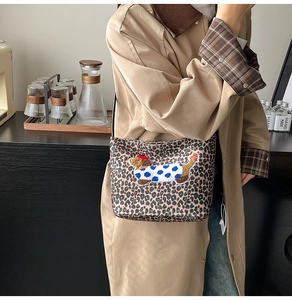 Détail du sac en toile léopard avec un patch brodé représentant un mignon teckel