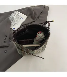 Vue détaillée du sac à bandoulière à carreaux montrant sa grande capacité de rangement
