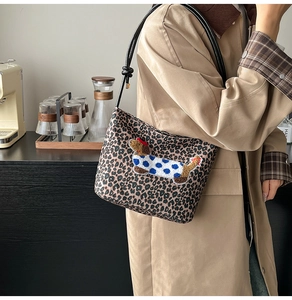 Sac seau à motif léopard avec broderie chien porté à l'épaule par un mannequin chic
