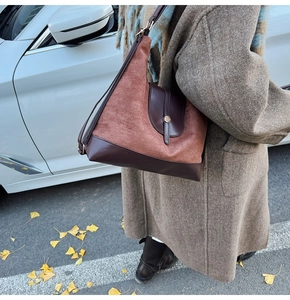 Vue détaillée de la texture bicolore en daim marron et cuir lisse avec boucle dorée