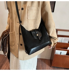 Détail du sac vintage noir avec texture en daim et fermoir métallique rond