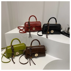 Macro shot of stylish PU leather bags in burgundy, black, green, and brown with metal locks