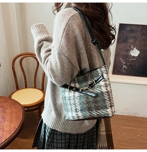 Detail of retro tweed bucket bag with leather strap and golden ring buckle decoration