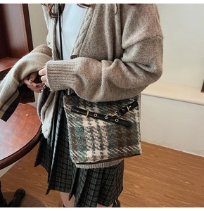 Detail of plaid wool shoulder bag featuring green check pattern and gold metal hardware
