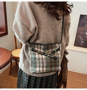 Detailed view of the vintage plaid crossbody bag in green and brown wool on a model