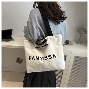 Détail du sac cabas en toile blanche avec imprimé FANYISSA noir et bandoulière robuste