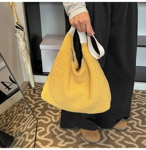 Vue détaillée du sac cabas en peluche jaune vif avec poignées en cuir blanc pour l'hiver