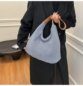 Détail du sac hobo en laine d'agneau bleu clair avec une bandoulière en cuir marron
