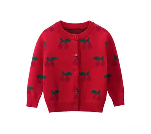 Detail of red knit cardigan with green leaf and cherry jacquard patterns for girls