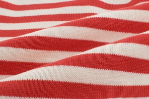 Gros plan sur le tissu en maille rayé rouge et blanc montrant sa texture douce et fine