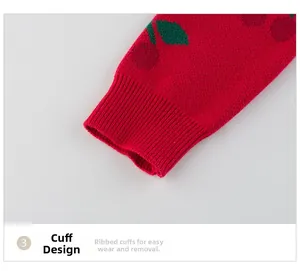 Detail of red knit sweater with cherry pattern and elastic ribbed cuffs for children