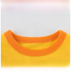 Detailed close-up of yellow knit cotton fabric and orange ribbed crew neck on kids' T-shirt