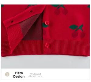 Detail view of red knit cardigan with cherry jacquard and wide ribbed hem construction