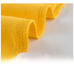 Detailed macro view of the inner stitching and white size label on a yellow cotton T-shirt