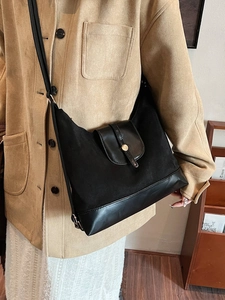 Grand sac hobo noir en cuir mat pour femme porté par un mannequin dans un style rétro