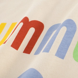Détail du tissu d'un t-shirt enfant en coton blanc crème avec imprimé lettres d'été colorées