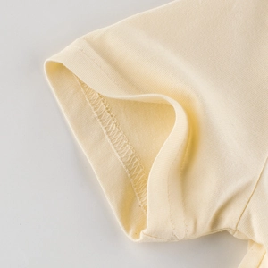 Détail du t-shirt beige pour fille montrant le bord-côte et la couture de haute qualité