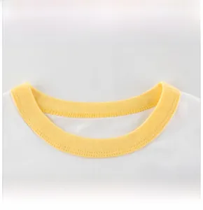 Dettaglio del girocollo con bordo giallo su maglietta per bambina in cotone bianco