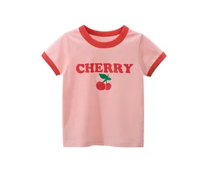 Close-up of pink cotton kids t-shirt with red cherry print and contrast collar