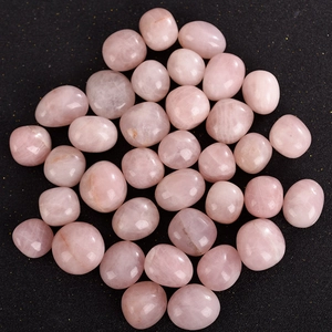 Natural rose quartz tumbled stones with smooth polished surface on a dark background