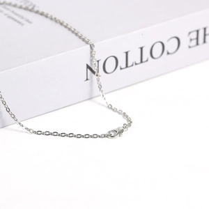 Silver-tone double-pointed crystal pendant with a detailed lobster clasp on a link chain