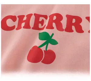 Detail showing high-quality red cherry print and CHERRY text on pink cotton T-shirt