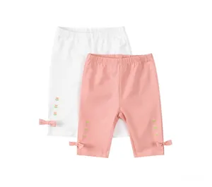 Dettaglio di leggings in cotone per bambina con ricamo floreale e fiocchi sull'orlo