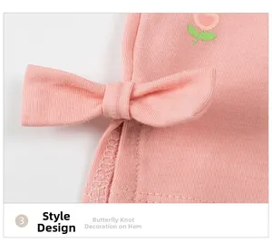 Dettaglio di leggings in maglia rosa con fiori ricamati e bordo con fiocco decorativo