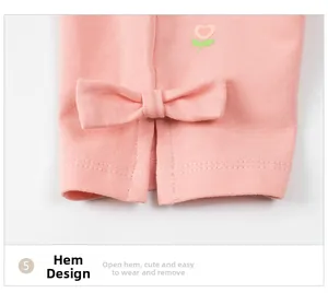Dettaglio di leggings rosa per bambine con fiori ricamati e fiocchi sugli spacchi laterali