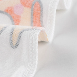 Gros plan d'un mouchoir pour bébé en coton avec motifs de dessins animés et couture fine