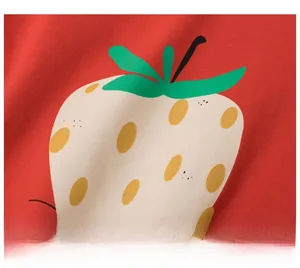 Close-up of a large yellow strawberry print on soft red cotton fabric for kids' T-shirt