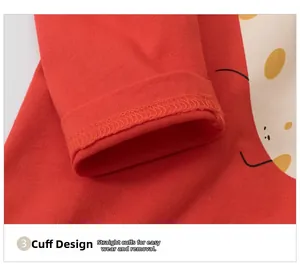 Detailed close-up of red cotton knit kids shirt sleeve with quality stitching and smiley print