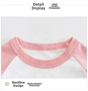 Detail of baby girl raglan tee showing pink white stitching and bound crew neck
