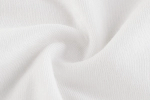 Macro shot of soft white knitted cotton fabric with fine texture and natural folds